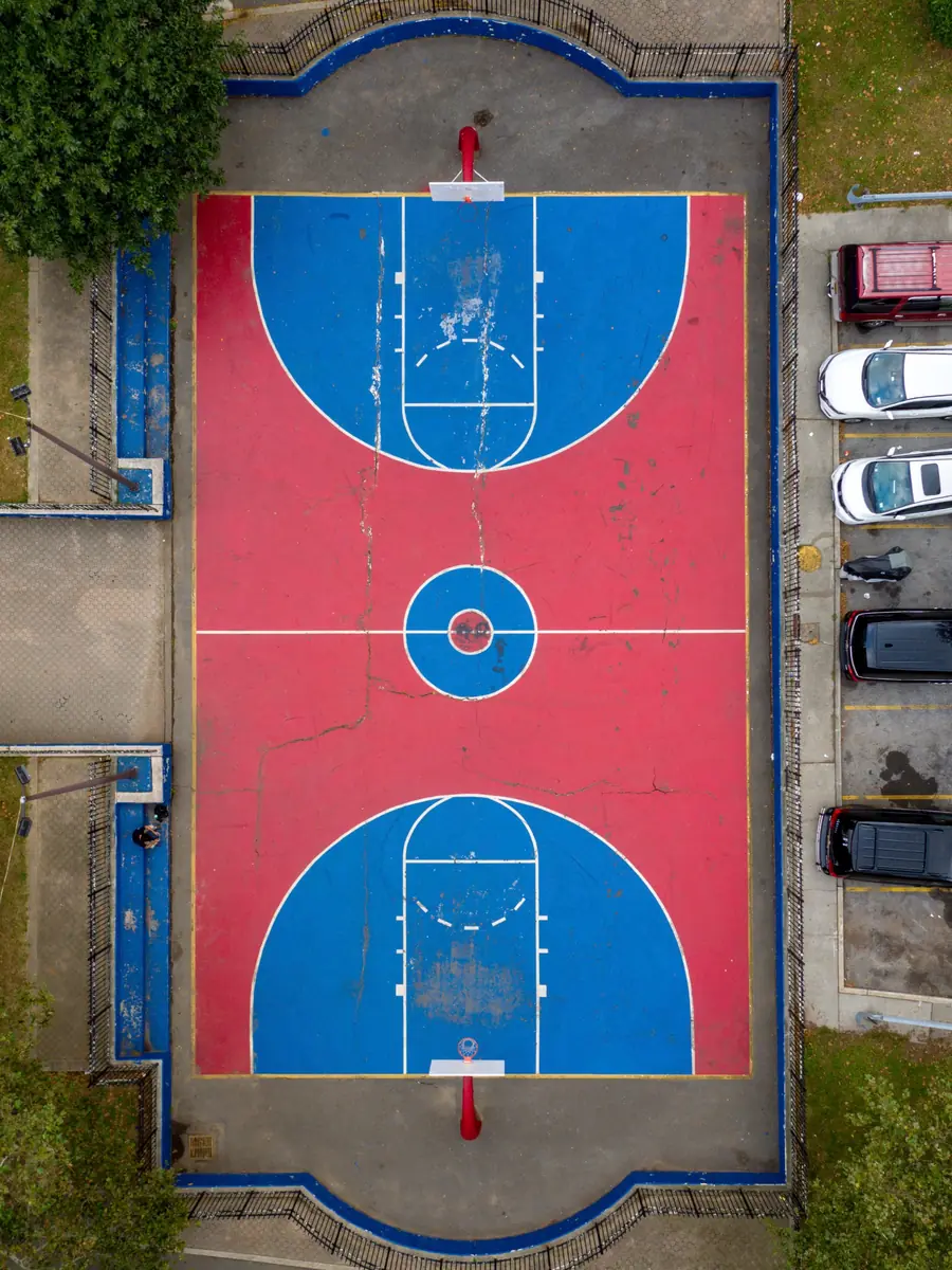 The same court before restoration, cracked red and blue paint with faded markings
